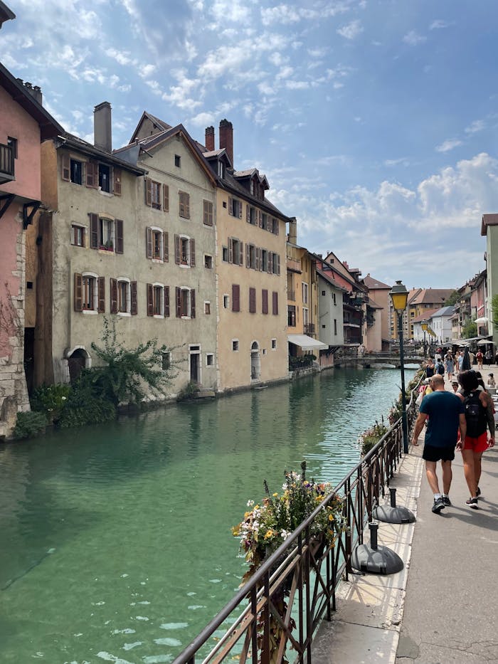 about-02 Picturesque canal view in Annecy, France, capturing vibrant summer life and historical architecture.